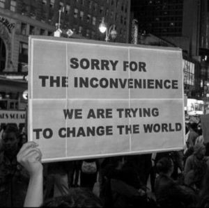 White sign that says " sorry for the inconvenience we are trying to change the world"