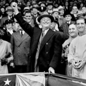 Picture of Franklin Delano Roosevelt waving his hand to a crowd of men and women behind him