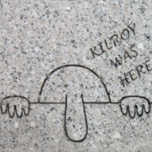 Drawing of person half showing his face with long nose over the wall