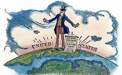 A globe with Uncle Sam standing on the Americas with a sign announcing the Monroe Doctrine.
