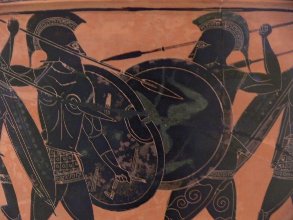 A black-figure Greek vase depicts two warriors with large, hoplite shields facing off in close combat.